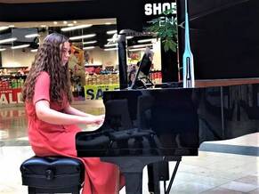 Piano student playing in a DVMTA recital at a mall